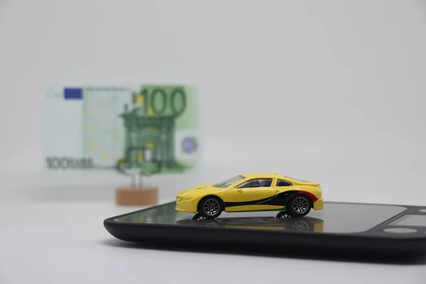 Oyuncak bir araba, satılırken arabanın fiyatını, araba sigortasını ve araba kredilerini belirleme kavramı, banknotu olan bir standın yanında elektronik ölçekte duruyor.