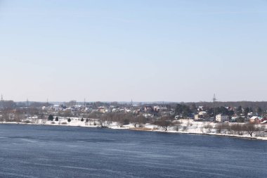 Güneşli bir günde nehir. Ağaçlar ve çalılar. Kış manzarası, nehir kıyıları çalılarla kaplı.