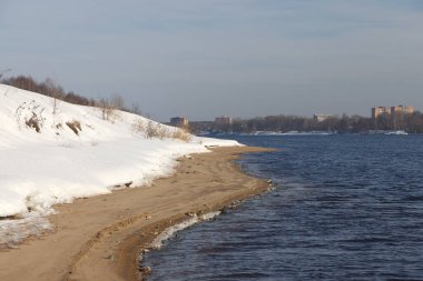 Güneşli bir günde nehir. Ağaçlar ve çalılar. Kış manzarası, nehir kıyıları çalılarla kaplı.