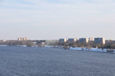 Güneşli bir günde nehir. Ağaçlar ve çalılar. Kış manzarası, nehir kıyıları çalılarla kaplı.
