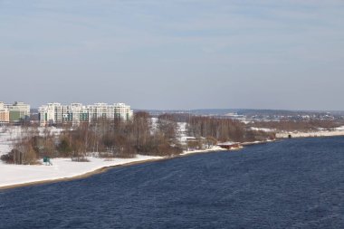 Güneşli bir günde nehir. Ağaçlar ve çalılar. Kış manzarası, nehir kıyıları çalılarla kaplı.