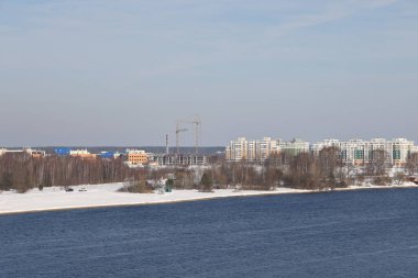 Güneşli bir günde nehir. Ağaçlar ve çalılar. Kış manzarası, nehir kıyıları çalılarla kaplı.