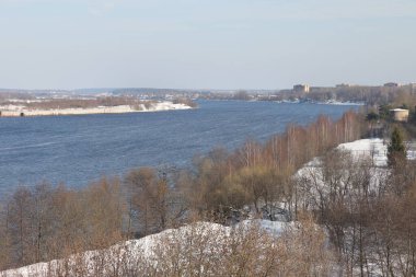 Güneşli bir günde nehir. Ağaçlar ve çalılar. Kış manzarası, nehir kıyıları çalılarla kaplı.