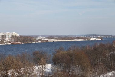 Güneşli bir günde nehir. Ağaçlar ve çalılar. Kış manzarası, nehir kıyıları çalılarla kaplı.