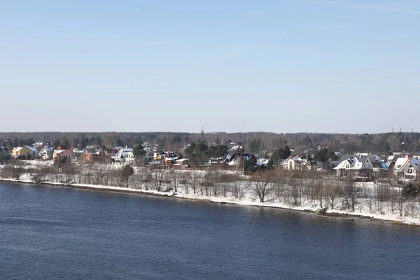 Güneşli bir günde nehir. Ağaçlar ve çalılar. Kış manzarası, nehir kıyıları çalılarla kaplı.
