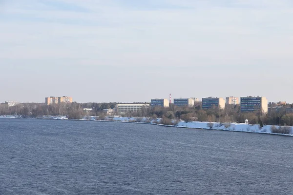 Güneşli bir günde nehir. Ağaçlar ve çalılar. Kış manzarası, nehir kıyıları çalılarla kaplı.
