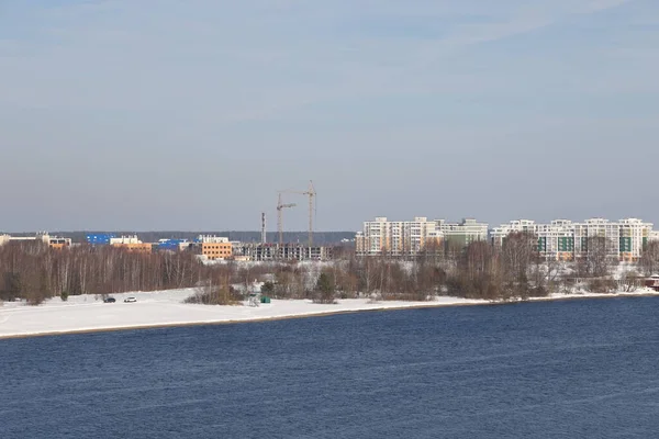 Güneşli bir günde nehir. Ağaçlar ve çalılar. Kış manzarası, nehir kıyıları çalılarla kaplı.