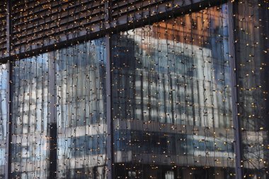 Gökdelenlerin geleceksel tasarımı açık mavi gökyüzüne karşı. Soyut cephe tasarımı. Modern şehir mimarisinde cam ve metal. Modern binaların dış görünüşü. Soyutlama. Geometri