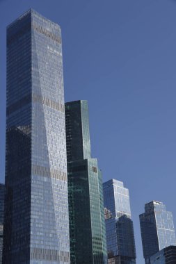 Gökdelenlerin geleceksel tasarımı açık mavi gökyüzüne karşı. Soyut cephe tasarımı. Modern şehir mimarisinde cam ve metal. Modern binaların dış görünüşü. Soyutlama. Geometri