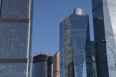 Gökdelenlerin geleceksel tasarımı açık mavi gökyüzüne karşı. Soyut cephe tasarımı. Modern şehir mimarisinde cam ve metal. Modern binaların dış görünüşü. Soyutlama. Geometri