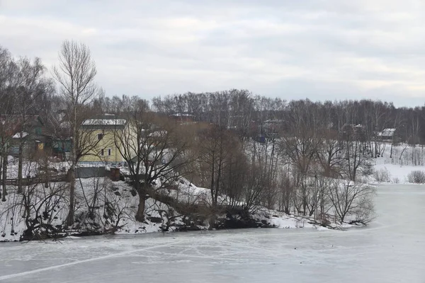 Spokojna Scena Jeziora Śniegiem Wczesną Wiosną Nachylenie Porośnięte Drzewami — Zdjęcie stockowe