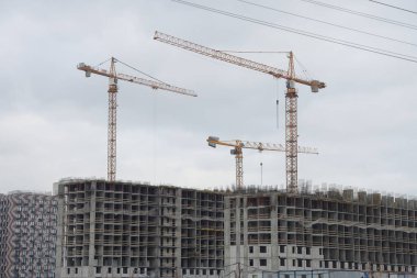 Vinçleri olan bir inşaat alanı. İnşaat makineleri, gökdelenler.
