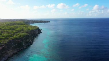 Aerial view of the coast of Curacao in the Caribbean Sea with turquoise water, cliff, beach, and beautiful coral reef