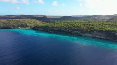 Aerial view of the coast of Curacao in the Caribbean Sea with turquoise water, cliff, beach, and beautiful coral reef