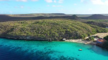 Aerial view of the coast of Curacao in the Caribbean Sea with turquoise water, cliff, beach, and beautiful coral reef