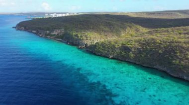 Aerial view of the coast of Curacao in the Caribbean Sea with turquoise water, cliff, beach, and beautiful coral reef