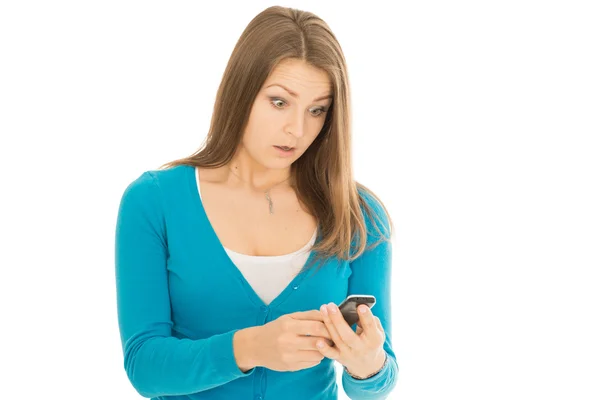 Beautiful woman looks at phone surprised — Stock Photo, Image