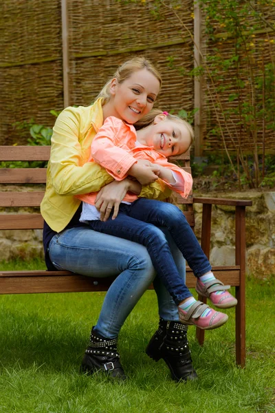 Mãe feliz abraça sua filha ao ar livre — Fotografia de Stock