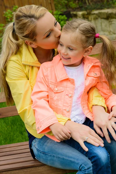 Happy mother hugs her daughter outdoor — Stock Photo, Image