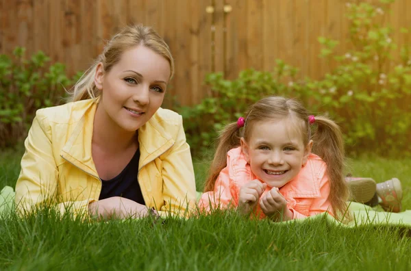 Happy family laying at grass — Stock Photo, Image