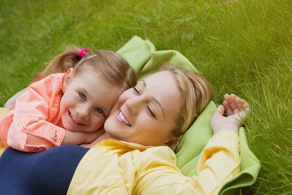 Happy family laying at grass — Stock Photo, Image