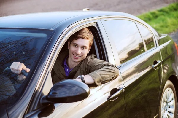 Homem feliz em seu carro novo sorri — Fotografia de Stock