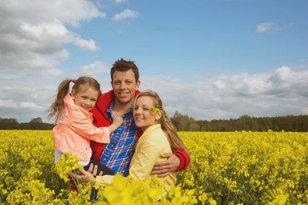 Happy family odkryty w pole rzepaku — Zdjęcie stockowe