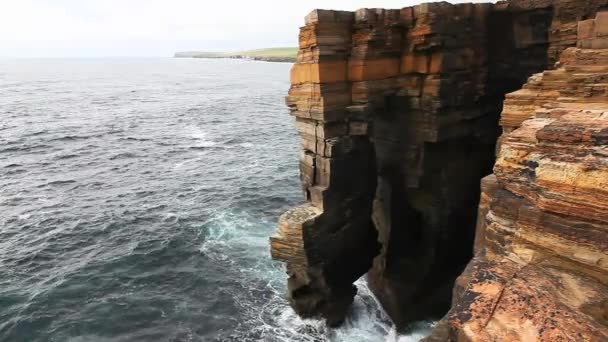 De grandes vagues s'écrasent contre de hautes falaises rocheuses aux Orcades, en Écosse — Video