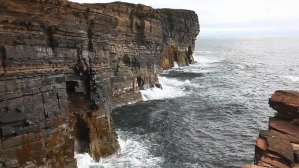 Des vagues s'écrasent contre de hautes falaises rocheuses aux Orcades, en Écosse — Video