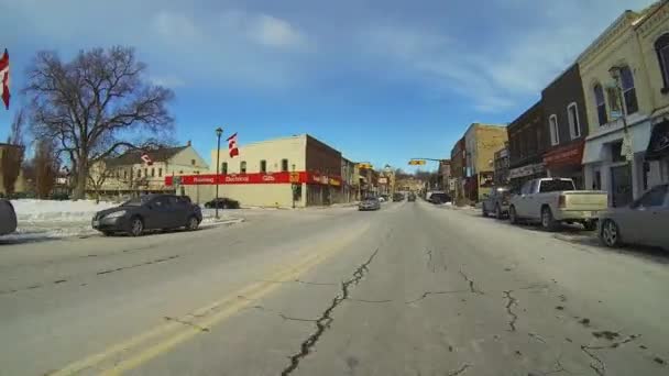 POV conduire à travers une petite ville en hiver — Video