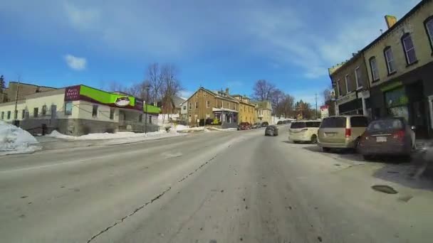 Зимний POV проехать через маленький городок в солнечный день — стоковое видео