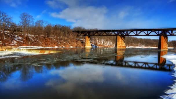 Winter Timelapse of fast flowing river with a railway bridge. — Stock Video