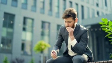 Beyaz sakallı bir iş adamı kenar mahalle arka planında şehir parkındaki bankta esrar içiyor. Erkek işçi, iş adamı. Takım elbiseli bir ofis çalışanı dışarıda bir marihuanayı rahatlatıyor.