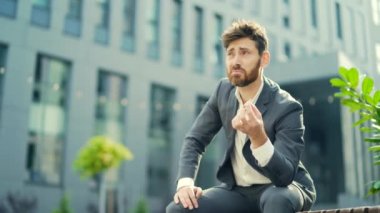 Beyaz sakallı bir iş adamı kenar mahalle arka planında şehir parkındaki bankta esrar içiyor. Erkek işçi, iş adamı. Takım elbiseli bir ofis çalışanı dışarıda bir marihuanayı rahatlatıyor.