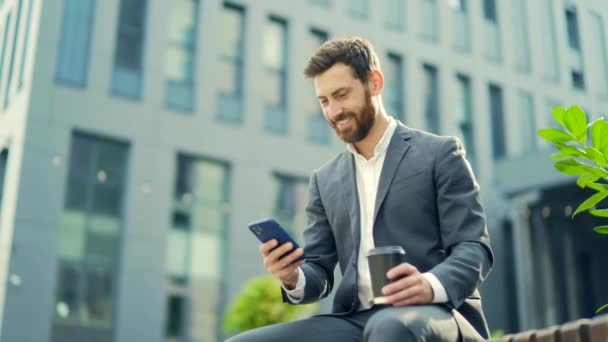 Guapo Empresario Barbudo Feliz Sentado Banco Con Taza Café Uso — Vídeos de Stock