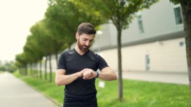 Beyaz sakallı, mutlu bir koşucu şehir parkının arka planında koşuyor. Sabah koşusu. Aktif sağlıklı yaşam tarzı uygunluğu. Dışarıda spor antrenmanı. Sporcu eğitim koşusu egzersizi