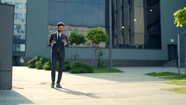 Успешный Молодой Уверенный Бизнесмен Движется Сотовым Телефоном Руках Фоне Современного — стоковое видео