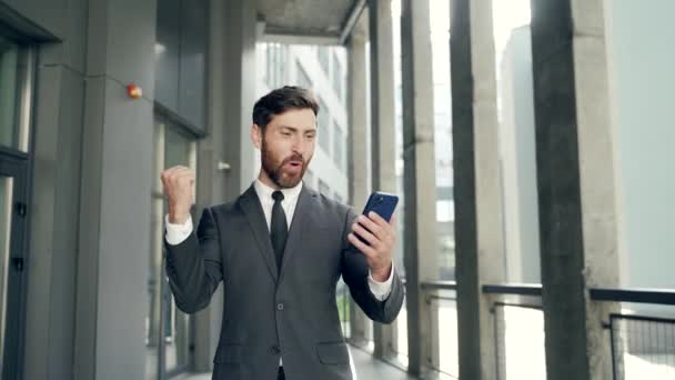 Exited Businessman Fira Prestation Tittar Smartphone Utomhus Framgångsrik Affärsman Firar — Stockvideo