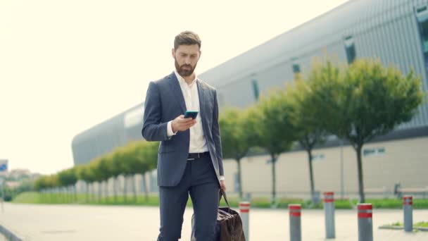 Stijlvolle Bebaarde Zakenman Met Reistas Mobiele Telefoon Handen Loopt Straat — Stockvideo