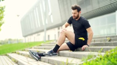 Kas ağrısı olan genç beyaz bir atlet. Adam masaj yapıyor, dışarıda koşarken travma yaralanması geçiriyor. Fitness erkeği şiddetli ağrı germe kuvveti burkulması. Bacağa kramp giren baldır sporu