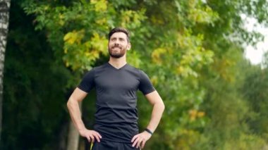 Kapalı portre genç mutlu sakallı adam ormanda ağaçların arasında duruyor rahatlıyor, gözlerini kapatarak temiz hava soluyor. Erkek, huzur dolu, parkta sakin bir hayatın tadını çıkarır. Açık havada. Mutluluk