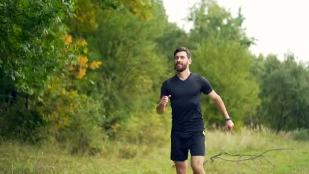 若い白人の髭を生やした幸せな男が森や都市公園でジョギングをしています 朝のジョギング アクティブな健康的なライフスタイルフィットネス スポーツワークアウト屋外 アスリートトレーニングは 新鮮な空気中で運動を実行する — ストック動画