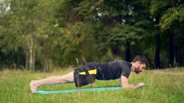 Jovem Com Barba Está Fazendo Fitness Parque Realizando Exercícios Tapete — Vídeo de Stock