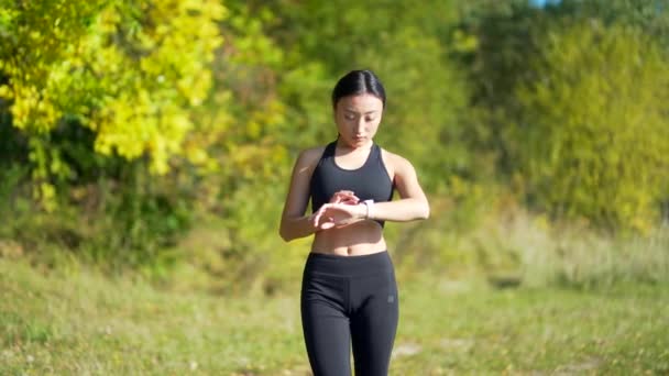 Zeki Asyalı Bir Kadın Modern Hipodrom Koşucusuna Akıllı Saat Takıyor — Stok video
