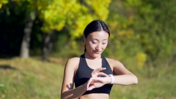 Deportiva Mujer Asiática Mirando Reloj Inteligente Corredor Pista Moderna Utilizando — Vídeo de stock