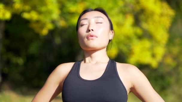 特写年轻快乐适合的亚洲女人站在大自然的林林间松驰 呼吸着新鲜空气闭上眼睛 在公园的室外 女人过着平静 宁静的生活 — 图库视频影像