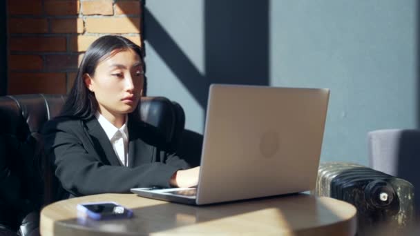 年轻的女自由职业者或在网上工作或在咖啡馆远程学习的学生 身穿西服的亚洲女商人在工作场所一起使用笔记本电脑 — 图库视频影像