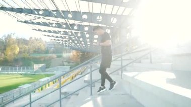 Asyalı erkek koşucu merdivenlerden inip modern şehir stadyumunun etrafında koşuyor. Kardiyo sabahı koşu merdiveni tırmanışı yapan adam dışarıda koşuyor. Adımlarda, şehirde spor sporu yapan bir sporcu. Aktif fitness sağlıklı 