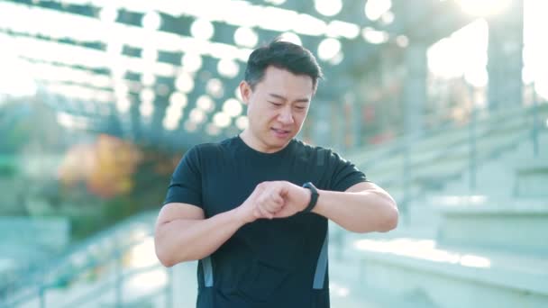 Sportovní Asiat Vypadá Chytře Hodinky Moderní Trati Muž Běžec Pomocí — Stock video