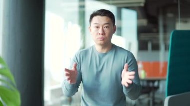 Webcam görüntüsü. Asyalı Erkek Serbest İşçi. Portre genç gülümseyen çalışan destek hizmetleri kamera, online iletişim, danışma, video görüşmesi, ofiste sanal toplantı